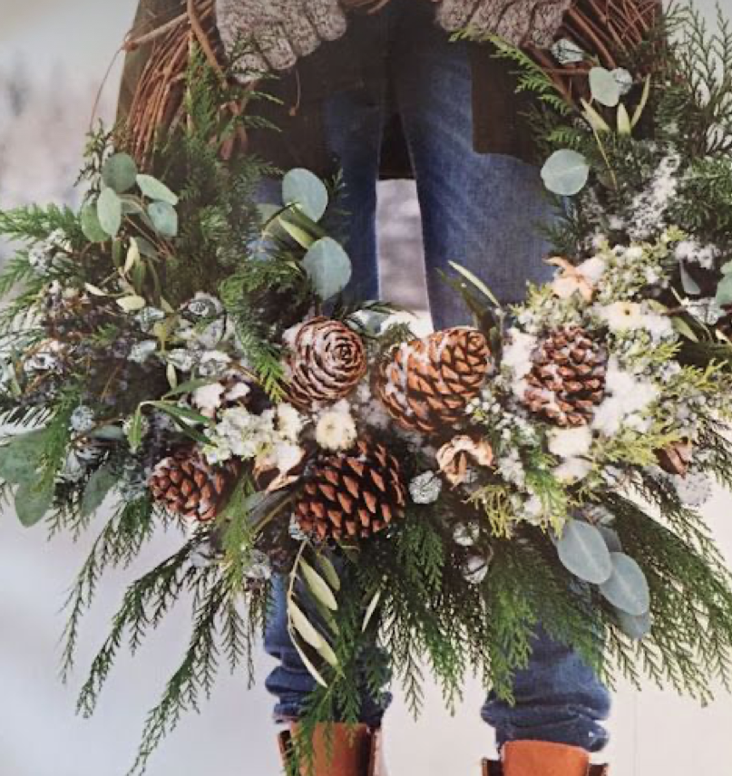 A natural looking Christmas wreath with pine cones and evergreen leaves