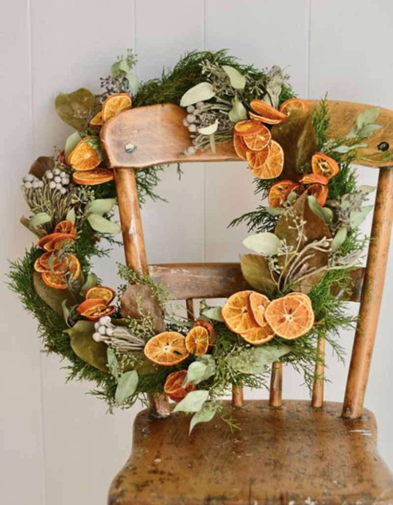 Homemade Christmas Wreath with evergreen leaves and dried orange pieces