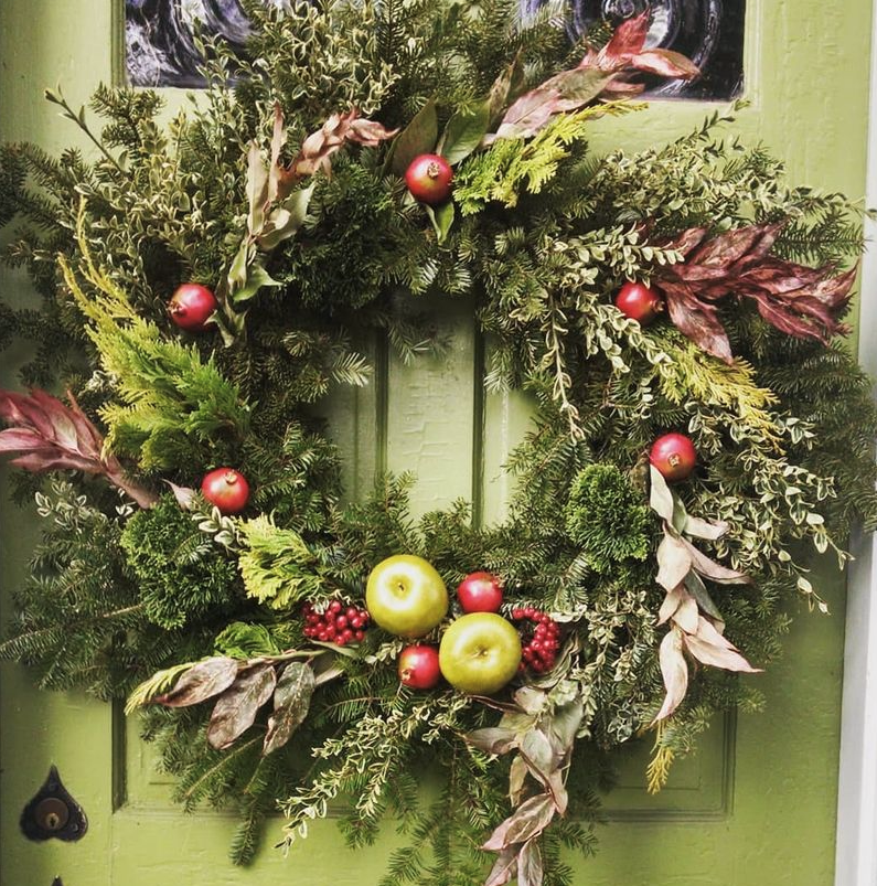 Christmas wreath with evergreen leaves, berries and fruit